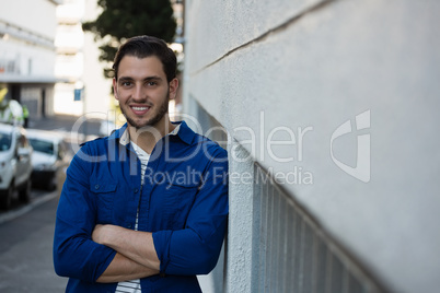 Portrait of smiling young man with arms crossed