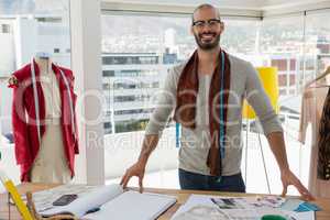 Fashion designer standing at table in studio