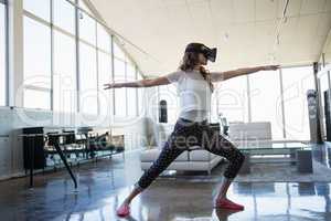 Businesswoman wearing virtual reality simulator exercising in office