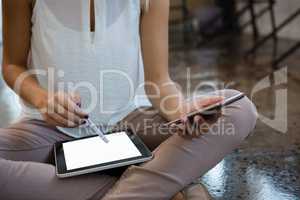 Midsection of woman using digital tablet at office