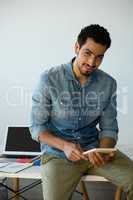 Portrait of man using digital tablet on desk at office