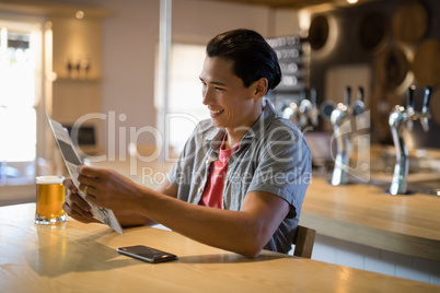 Man reading newspaper in a restaurant