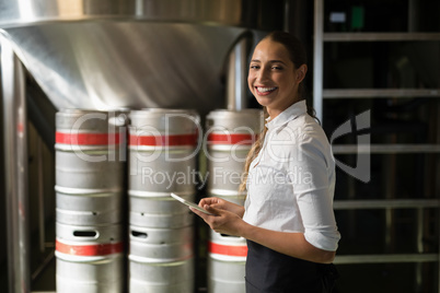 Smiling waitress using digital tablet in bar