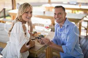 Smiling man giving engagement ring to woman