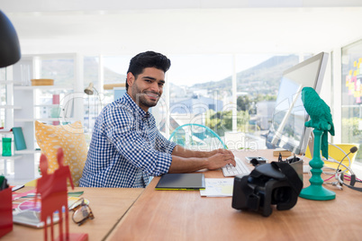 Graphic designer working on computer at desk