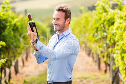 Smiling young man holding wine bottle