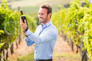 Smiling young man holding wine bottle