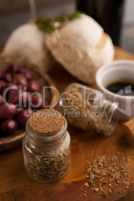High angle view of spices in jar with olives and bread