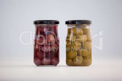 Close up of green and brown olives in glass jar
