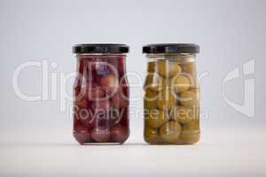Close up of green and brown olives in glass jar
