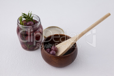 Red olives in jar and container and spoon