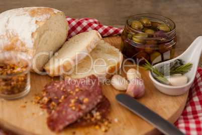 Close up of meat and bread by olives in container