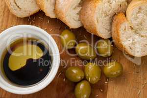 Close up of olives with bread and oil in container