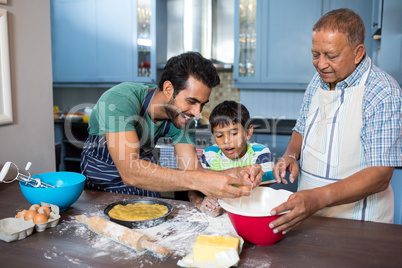 Boy looking at father breaking egg