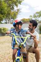 Son talking to father while sitting on bicycle