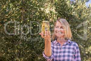 Happy woman examining pickled olive in farm