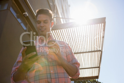 Low angle view of young man using mobile phone