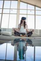 Woman mediating while using virtual reality simulator in office