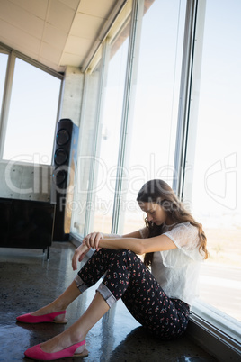 Full length of tired businesswoman sitting on floor