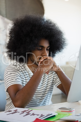 Man with curly hair sitting at desk
