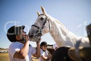 Boy kissing the white horse in the ranch