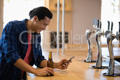 Man using mobile phone at counter