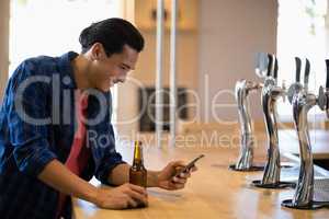 Man using mobile phone at counter