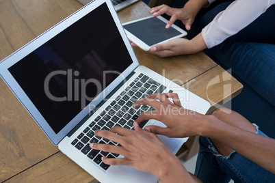 Executives using digital tablet and laptop in the office