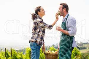 Woman feeding apple to man at vineyard