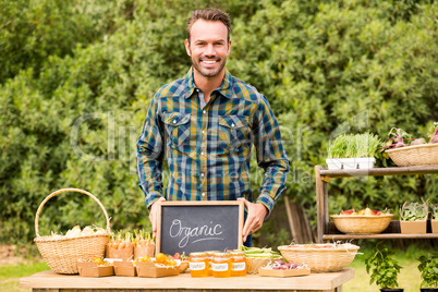 Portrait of man with blackboard selling organic vegetables