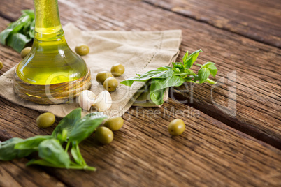 Olive oil and ingredients on wooden table