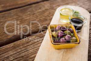 Marinated olive, rosemary with olive oil and balsamic vinegar on table