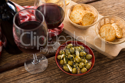 Close-up of marinated olives with glasses of wine