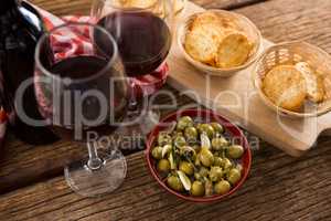 Close-up of marinated olives with glasses of wine