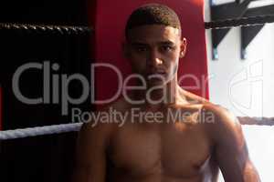 Portrait of confident man sitting in boxing ring