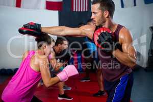 Female boxer defending with instructor