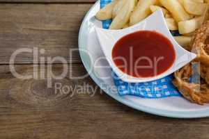 Onion ring and french fries with ketchup arranged in plate