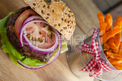 Hamburger and french fries on chopping board