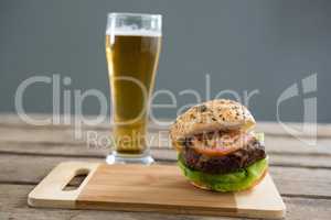 Close up of hamburger on cutting board by beer