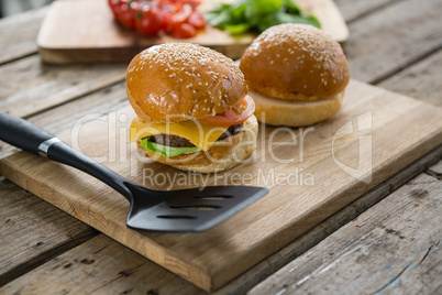 Close up of burgers and vegetables on cutting board