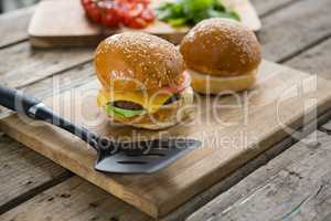 Close up of burgers and vegetables on cutting board