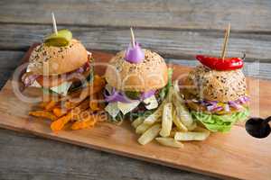 Various burgers on cutting board