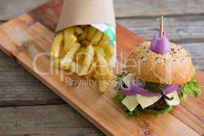 High angle view of burger by French fries in box on cutting board