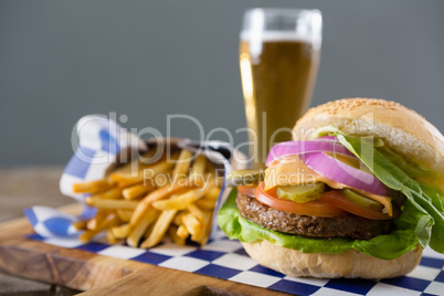 Close up of hamburger served with french fries and beer