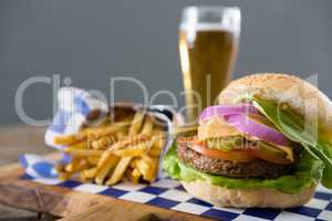 Close up of hamburger served with french fries and beer