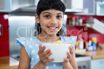 Close-up portrait of smiling girl with breakfast bowl