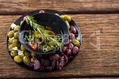 Pickled olives and vegetables with rosemary in bowl