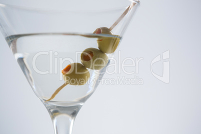 Cocktail martini with olives on table