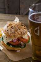 Hamburger in chopping board with glass of beer