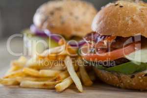 Hamburger and french fries on wooden table